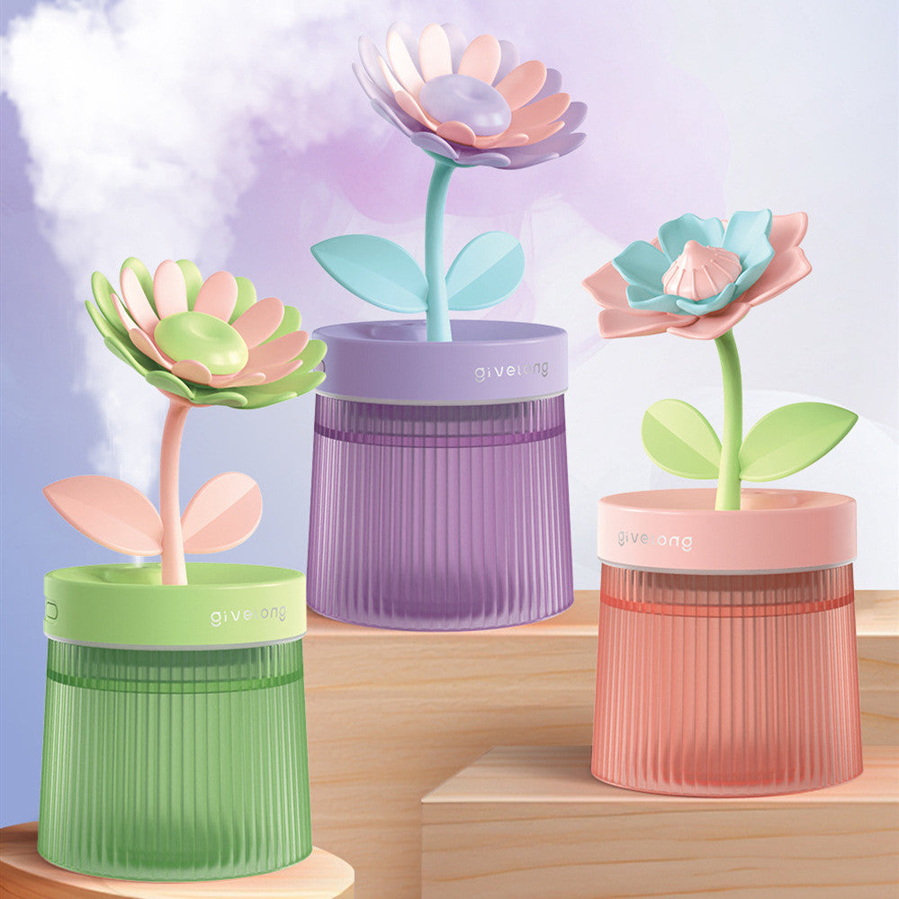 Three colorful flower-shaped humidifiers on a wooden surface with a light purple background.